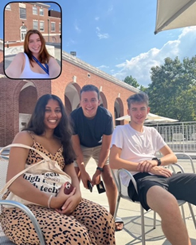 Tres estudiantes se sientan fuera con un selfie del fotógrafo en una esquina