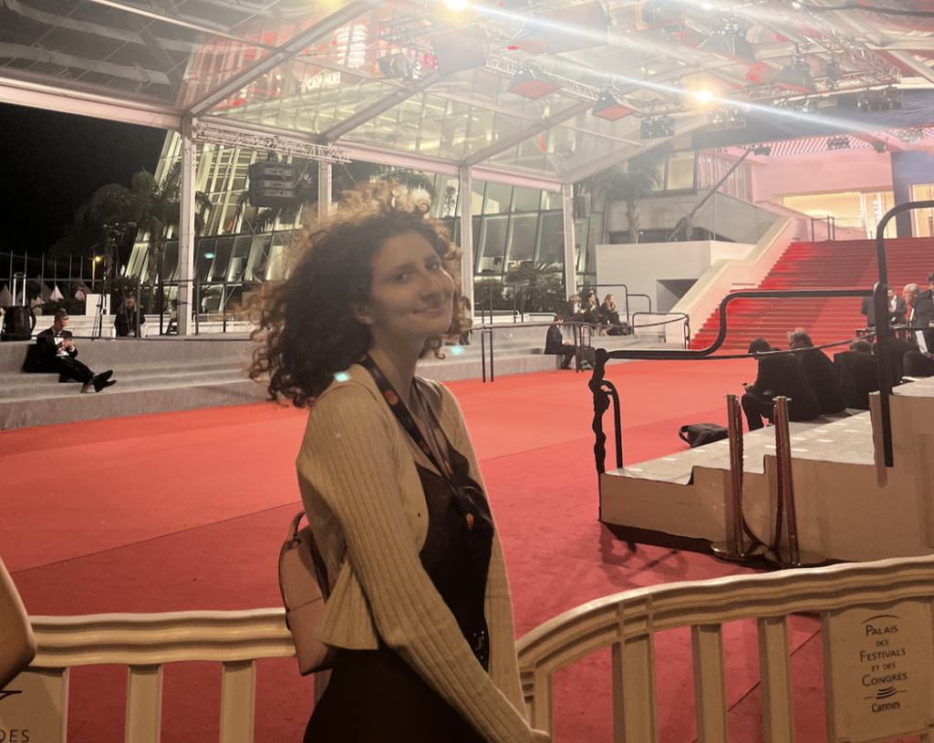 A young woman in front of a red carpet