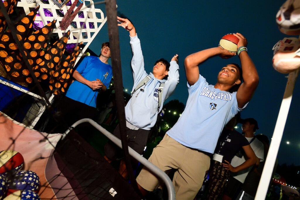 Students playing basketball at an on-campus carnival
